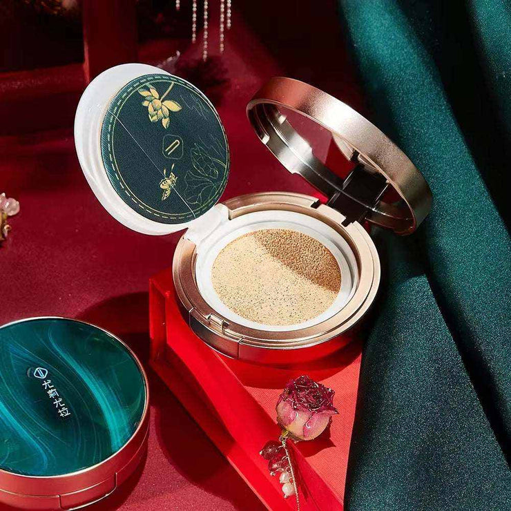 8Pcs Makeup Set Gift Box with foundation cushion compact on red and green fabric background