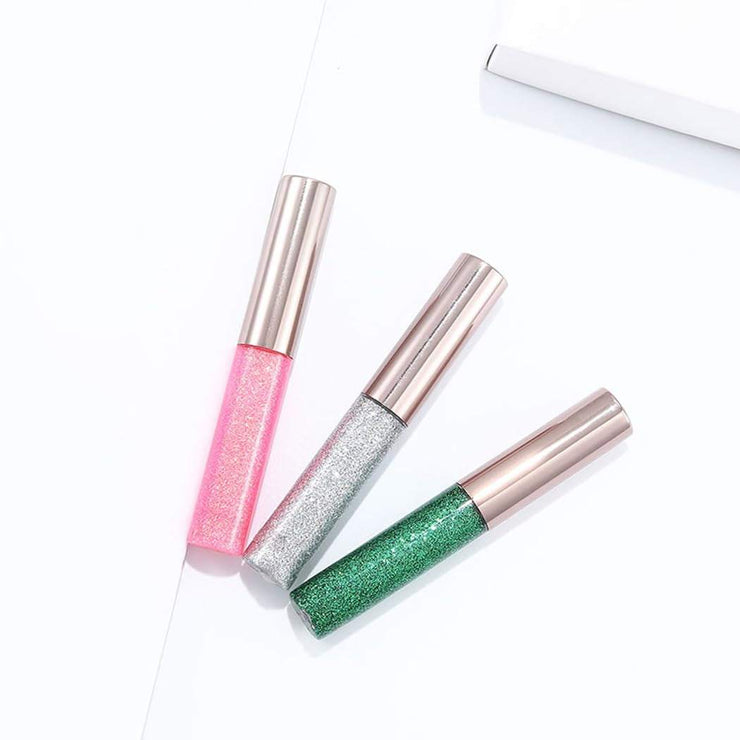 Pack of three glitter liquid eyeliners in pink, silver, and green with metallic shimmer and felt tip for smooth application and vibrant eye makeup.