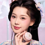 Woman with natural makeup holding Butterfly Cloud Collar Rouge Box highlighting and blush duo powder compact