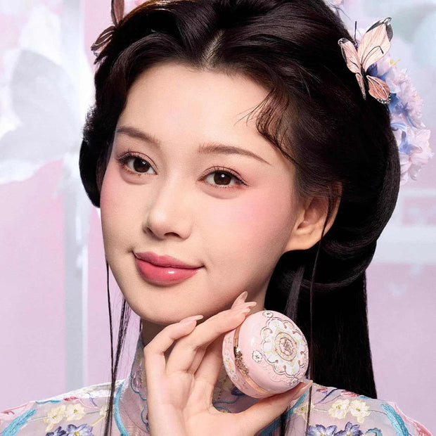 Woman with natural makeup holding Butterfly Cloud Collar Rouge Box highlighting and blush duo powder compact