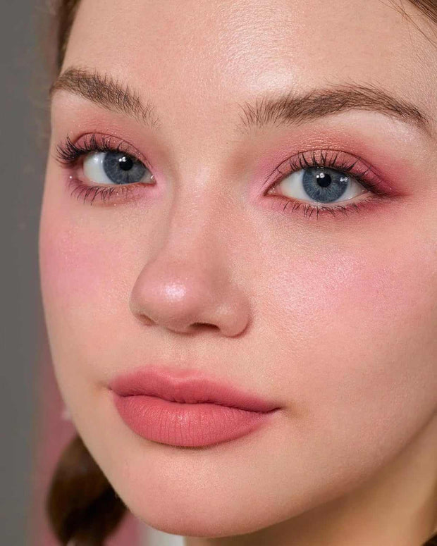 Close-up of a woman wearing pink eyeshadow, blush, and lipstick from the Strawberry Cupid Makeup Palette S02 Cupid's Mischief with matte and shimmer finishes.