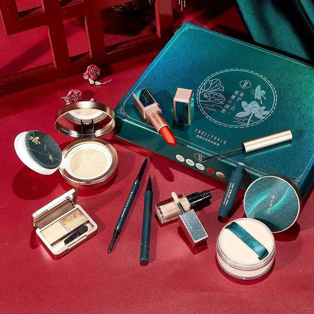 8pcs women's makeup set gift box with lipstick, concealer, foundation, eyeshadow palette, and setting powder on red background