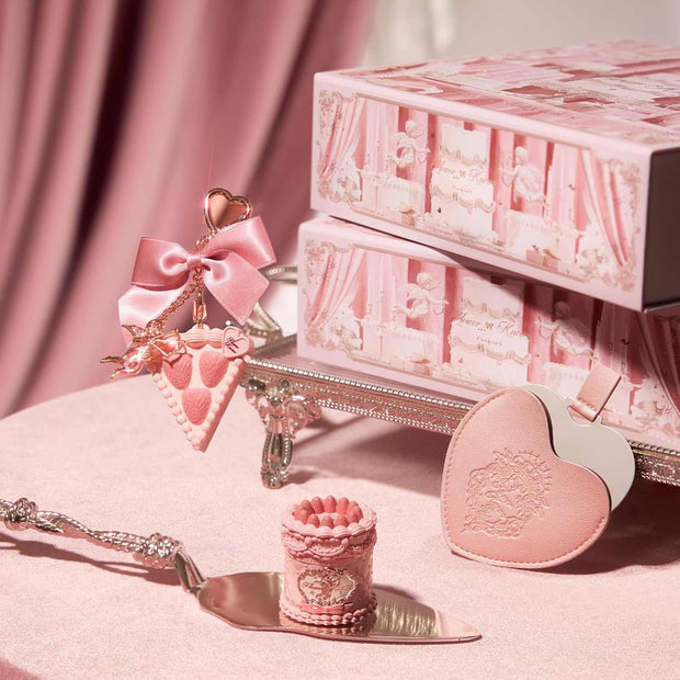 Strawberry Cupid Makeup set with pink heart-shaped compact, decorative box, and ornate applicator on pink velvet background